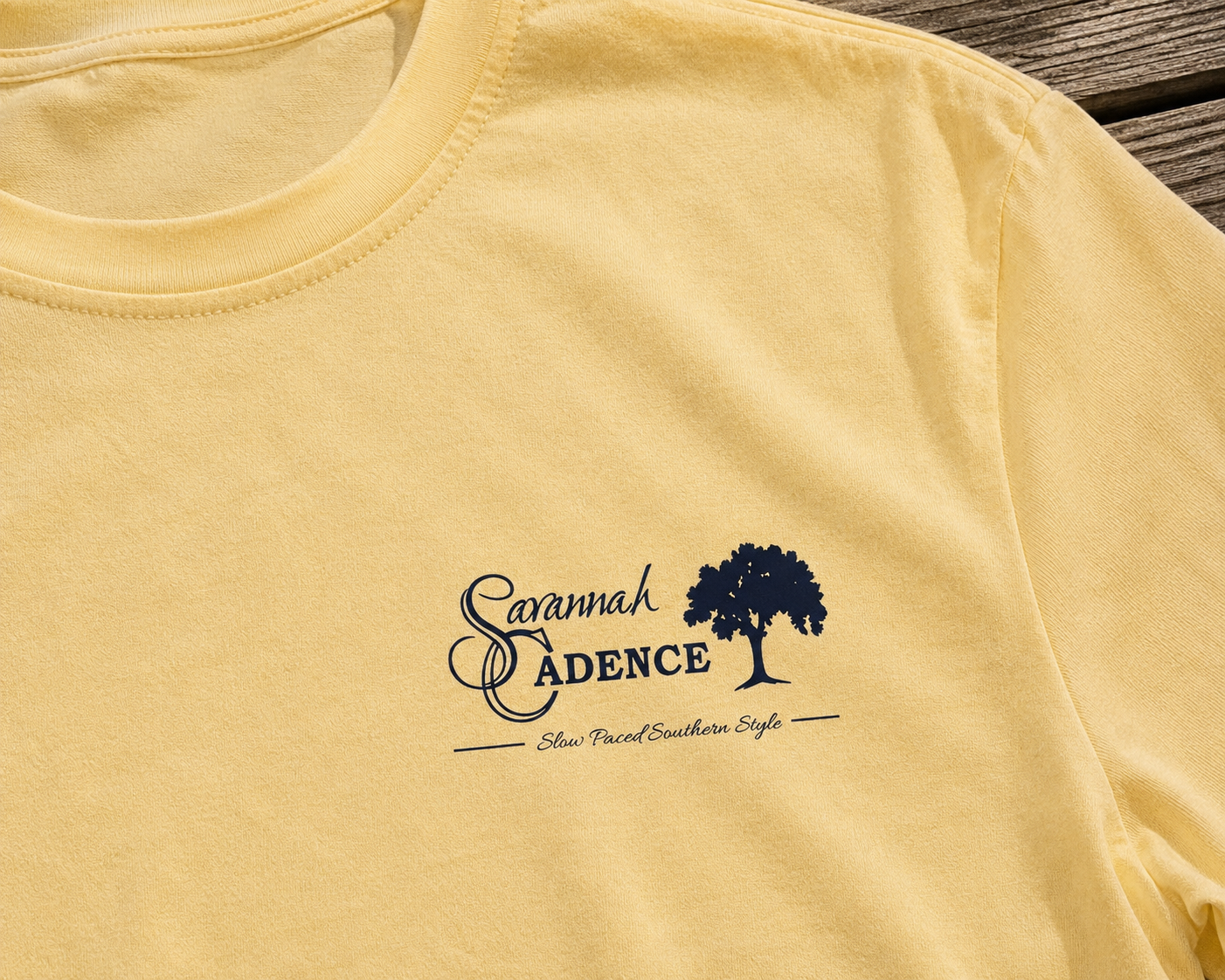 Close-up of the Savannah Cadence front chest logo on a premium cream Southern lifestyle T-shirt.