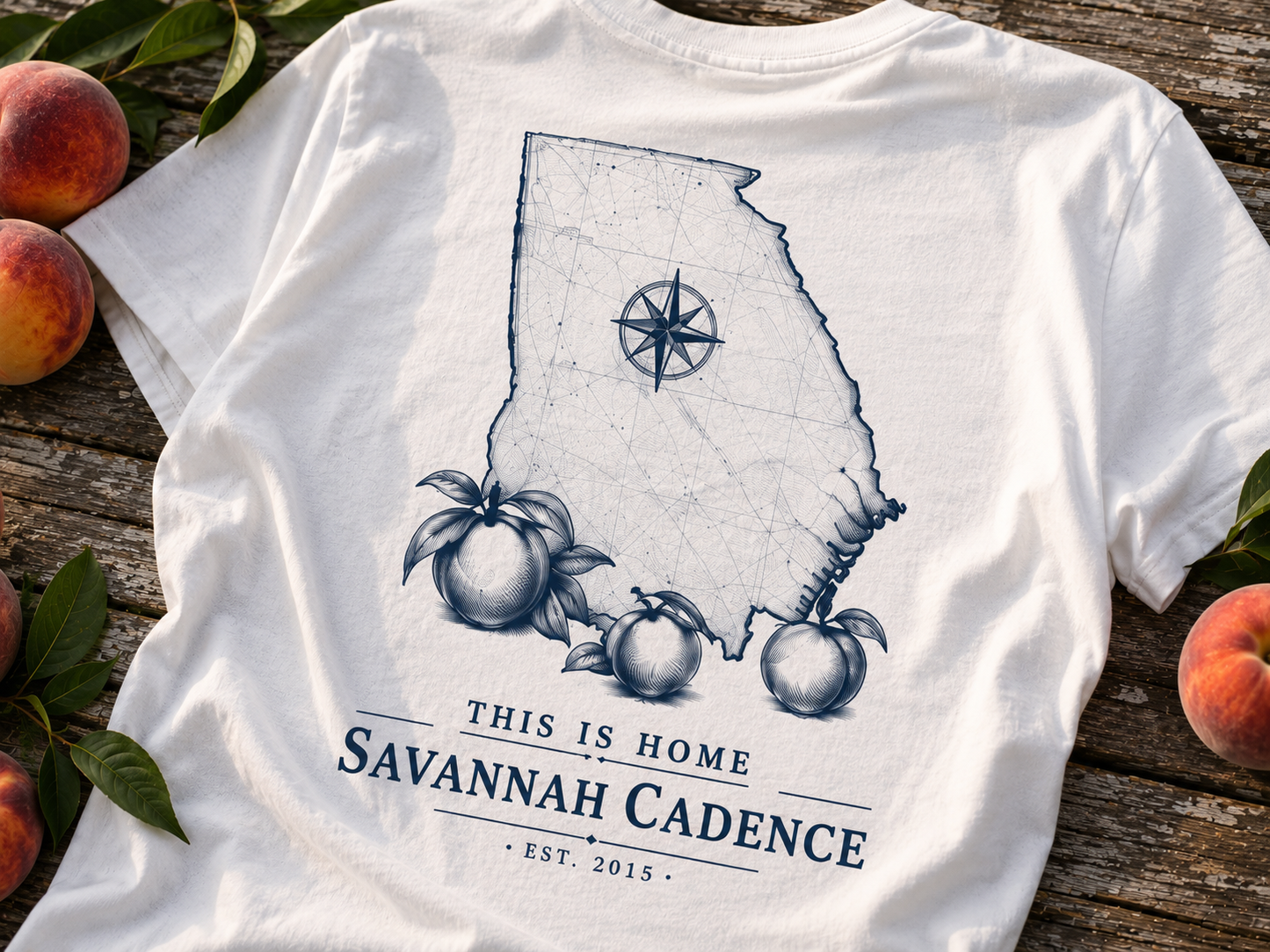 Close-up of the Savannah Cadence This Is Home Georgia map artwork with peaches on a white Next Level 6210 t-shirt.